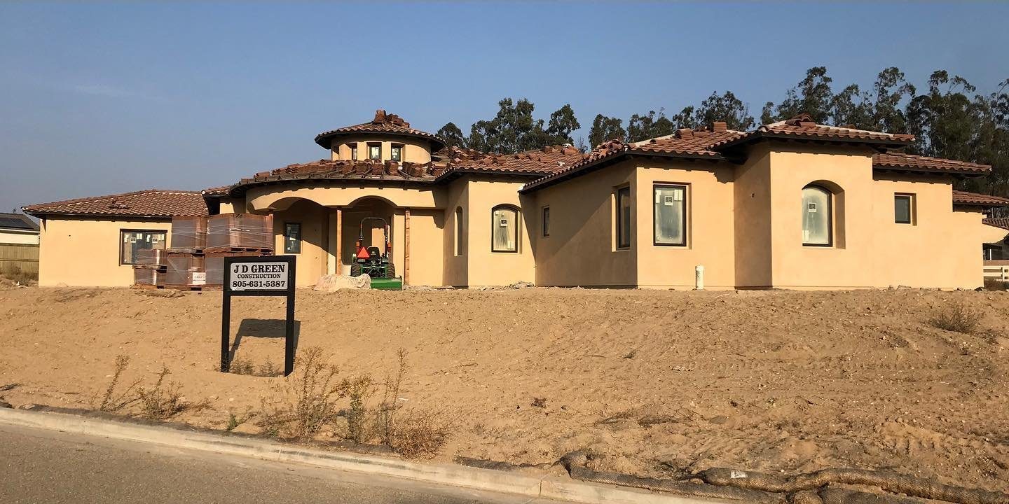 After: the finished stucco home with a tile roof