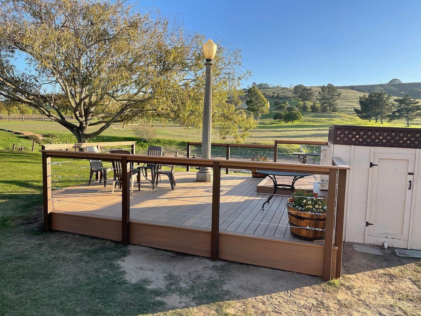 New wood deck with railing overlooking a green valley