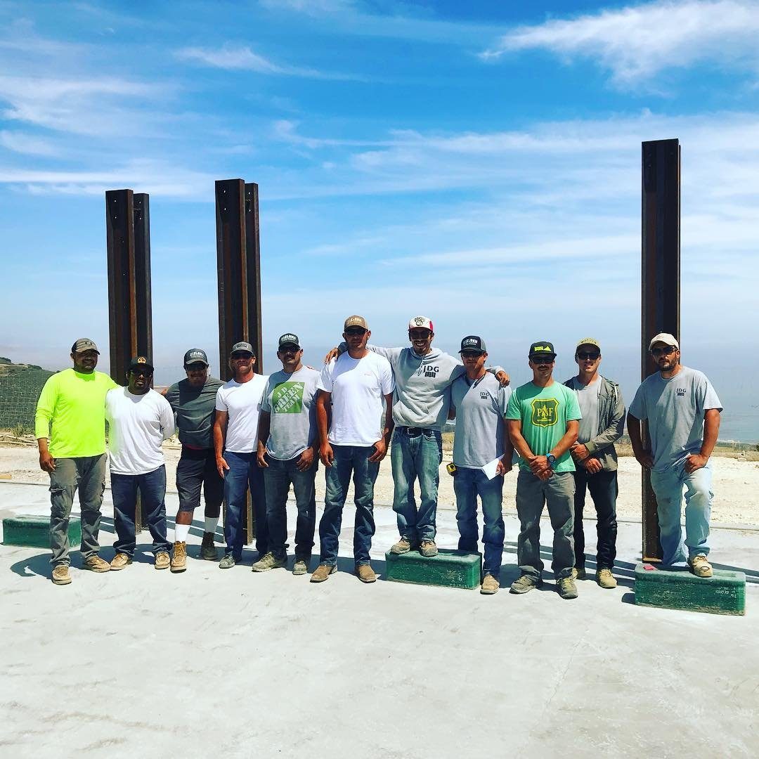 JD Green Construction team standing in front of steel columns on a job site
