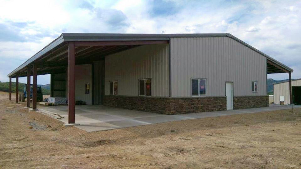 Completed steel building with stone wainscot and a covered bay